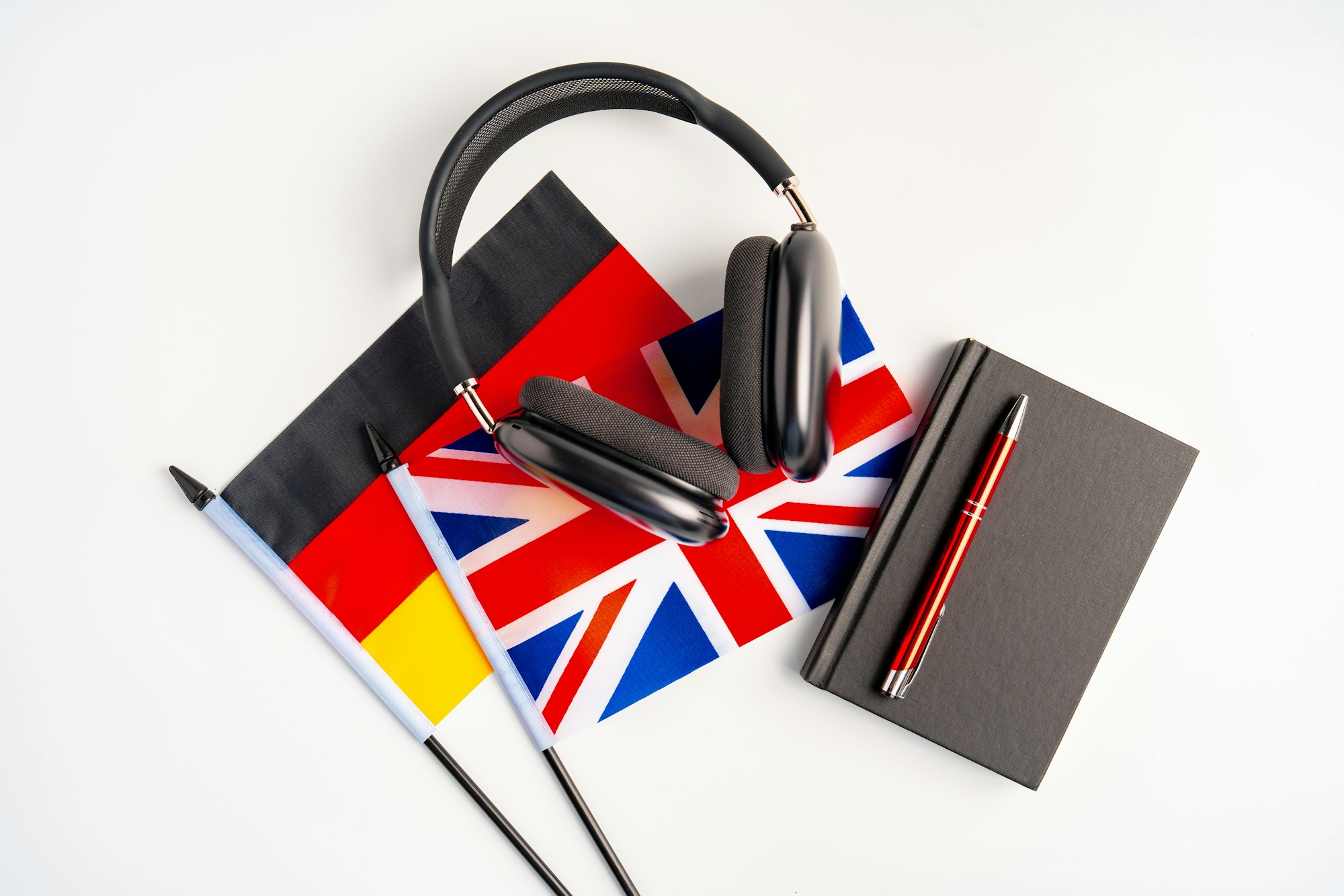 German and British flags with notepad on white background