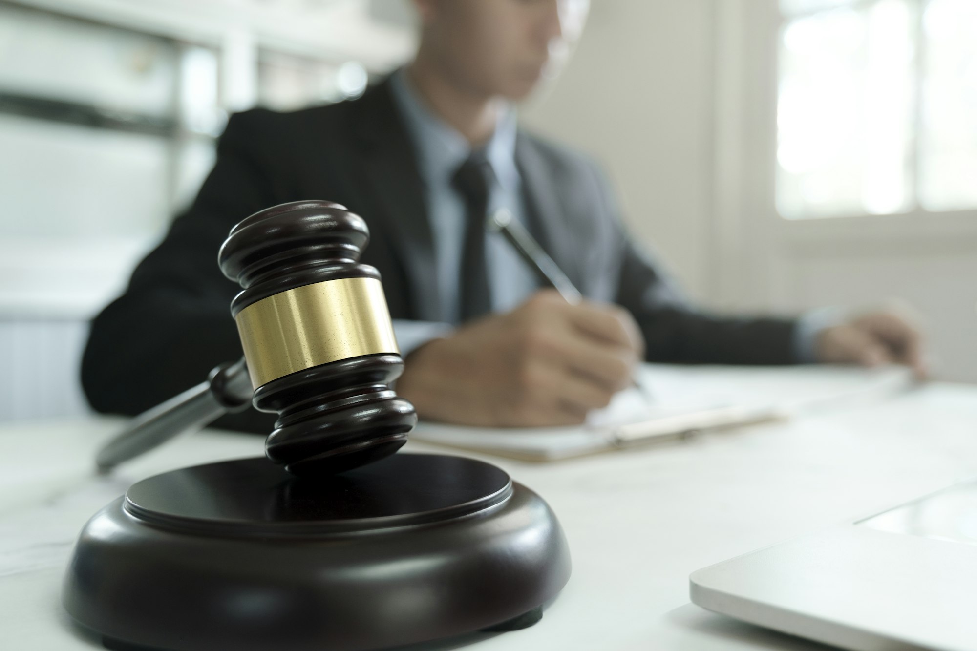 Male lawyer in the office with brass scale.