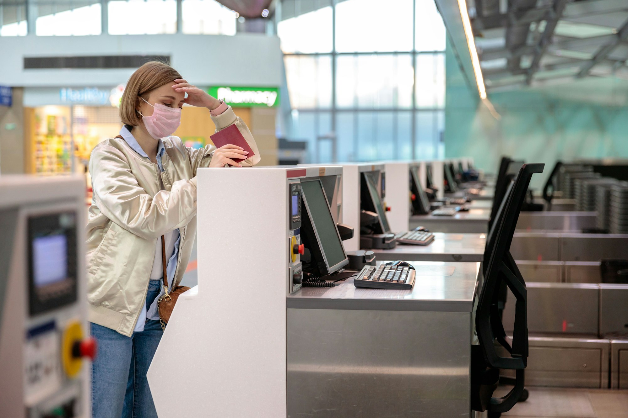 Woman passenger wear face mask stand with luggage at empty check-in counters at airport. Covid-19.